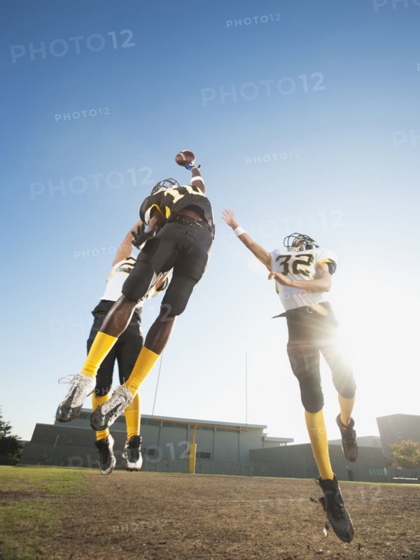 Football player catching ball on football field