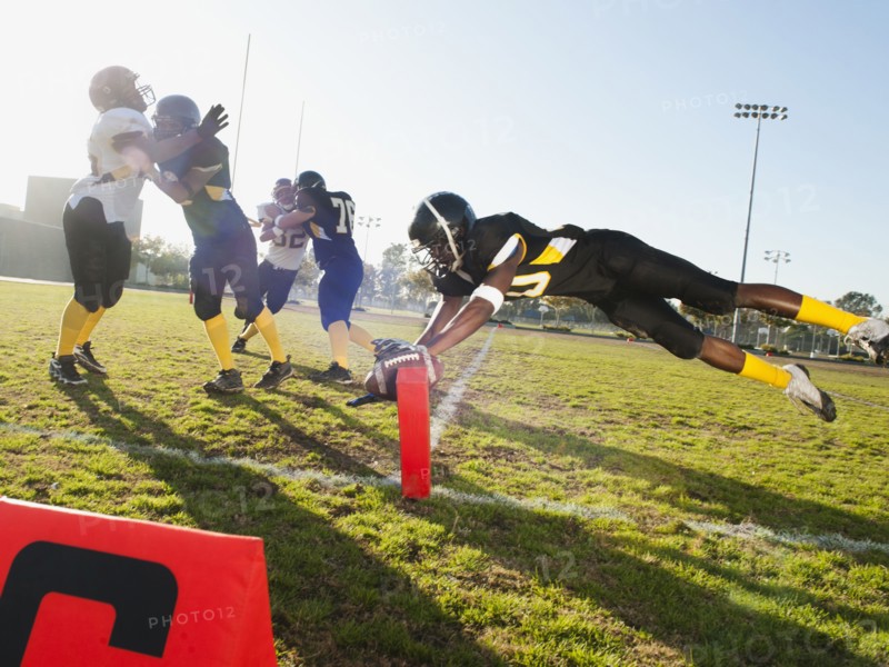 Football player scoring goal on football field
