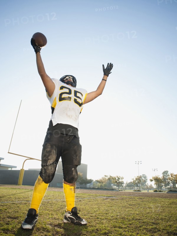 Hispanic football player cheering on football field