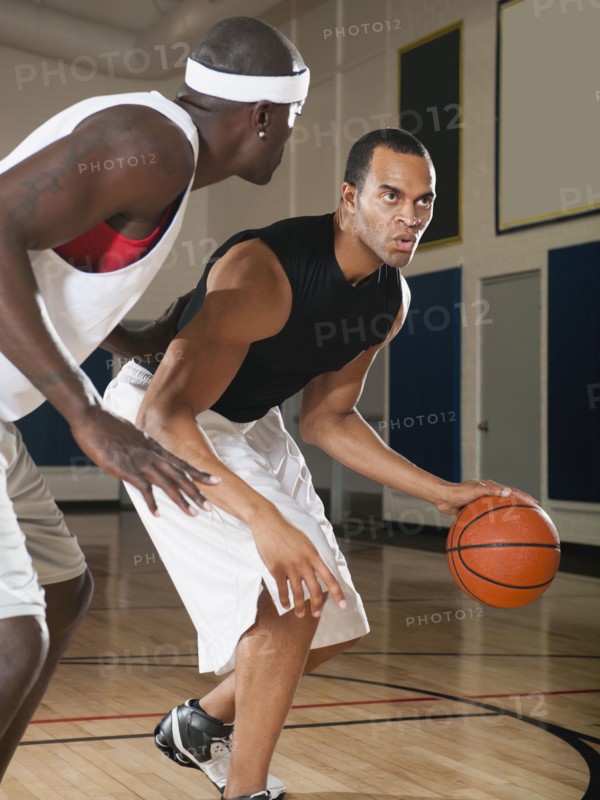 Men playing basketball on basketball court