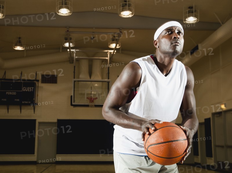 Black man shooting basketball on basketball court