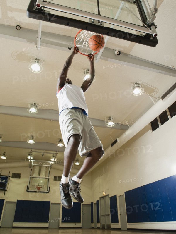 Black man shooting baskets on basketball court