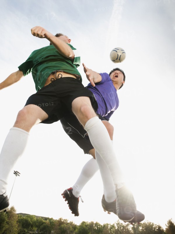 Soccer players heading soccer ball