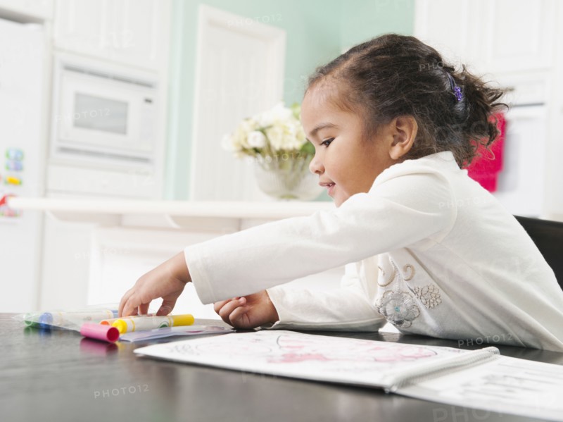 Mixed race girl drawing in notebook