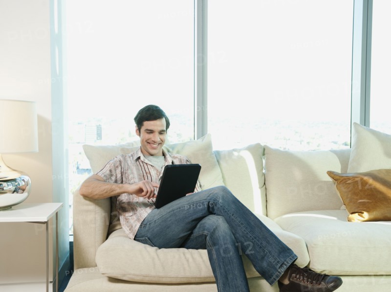 Caucasian man using digital tablet in living room