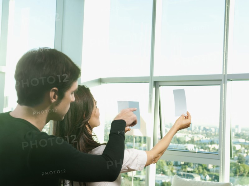 Couple looking at color swatches near window