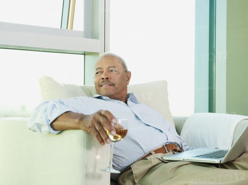 Black man drinking wine and reading book