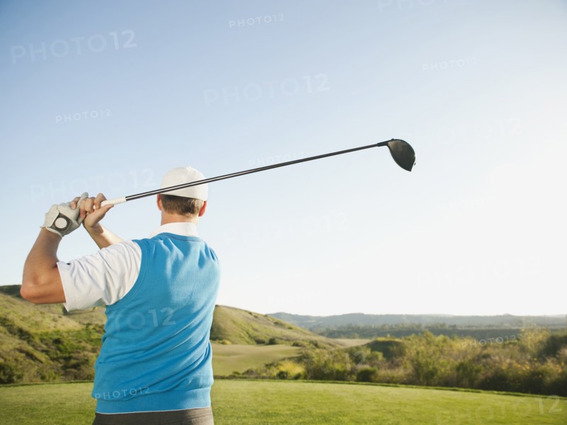 Caucasian golfer swinging golf club