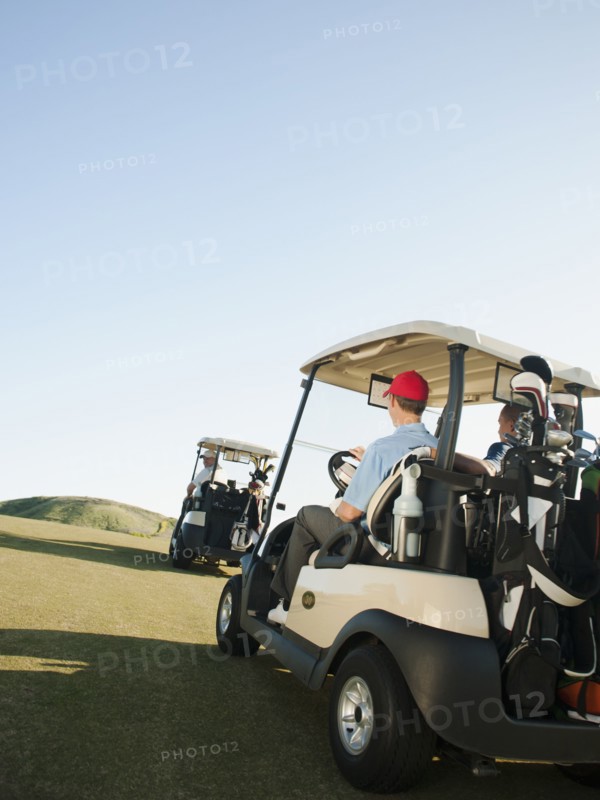 Men driving golf carts on golf course