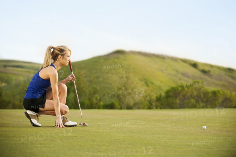 Caucasian woman checking ground on golf course
