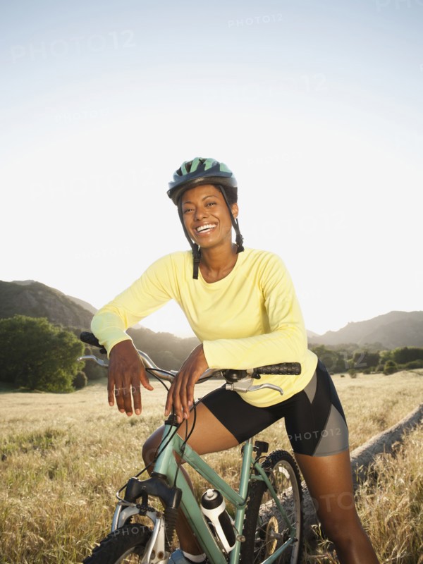 Mixed race biker standing with mountain bike