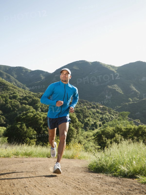 Mixed race man running on remote trail
