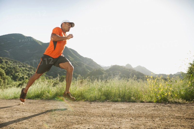 Mixed race man running on remote trail