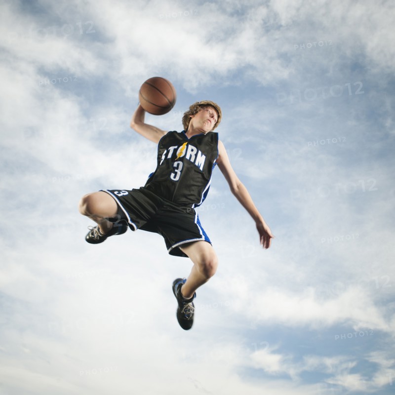 Caucasian teenager playing basketball