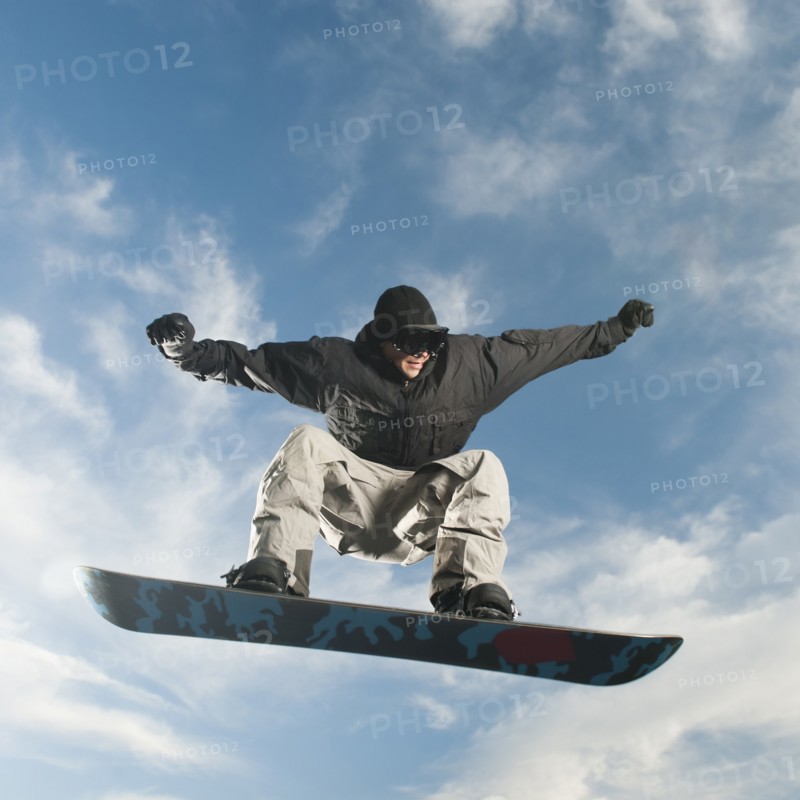 Caucasian man on snowboard in mid-air