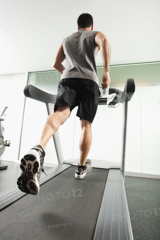 Mixed race man running on treadmill