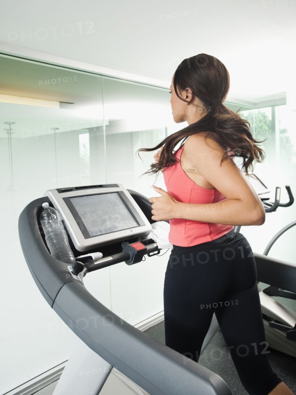 Mixed race woman running on treadmill