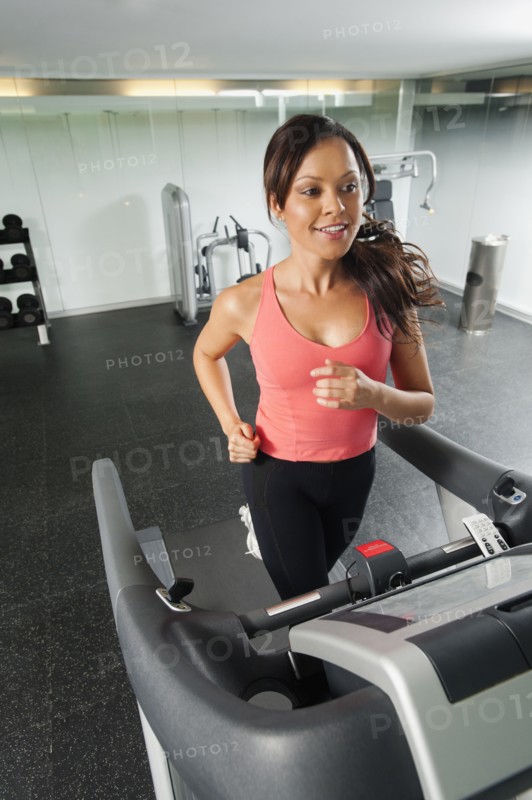 Mixed race woman running on treadmill
