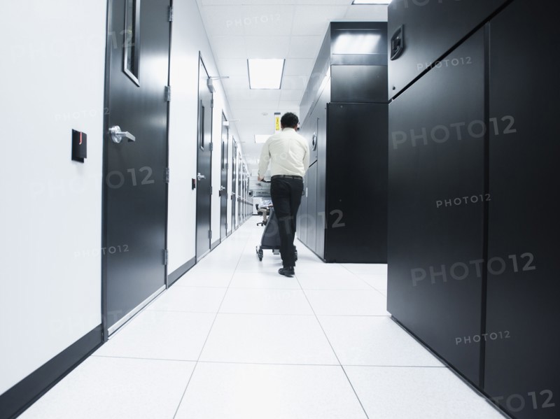 Asian businessman walking in server room
