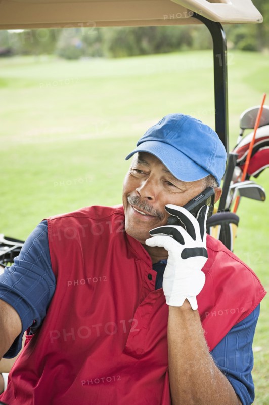 Black man on cell phone in golf cart