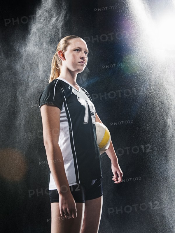 Caucasian volleyball player standing under lights