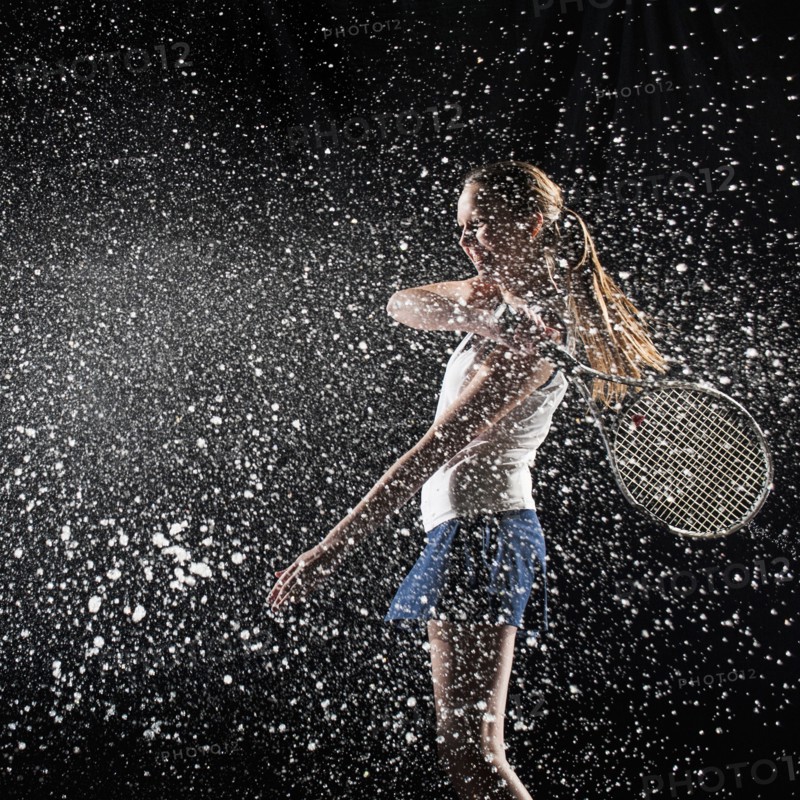 Caucasian tennis player splashing in water