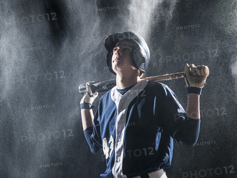 Caucasian baseball player standing in rain
