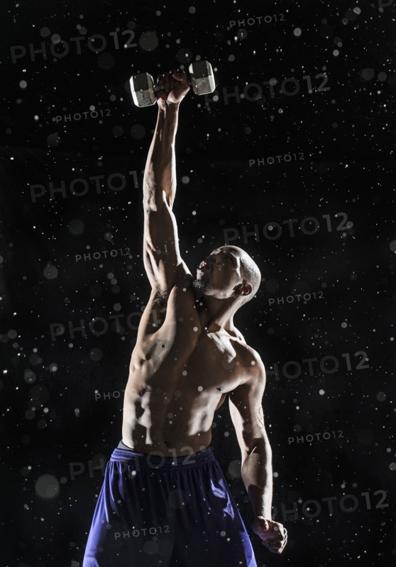 African American athlete lifting weights in rain
