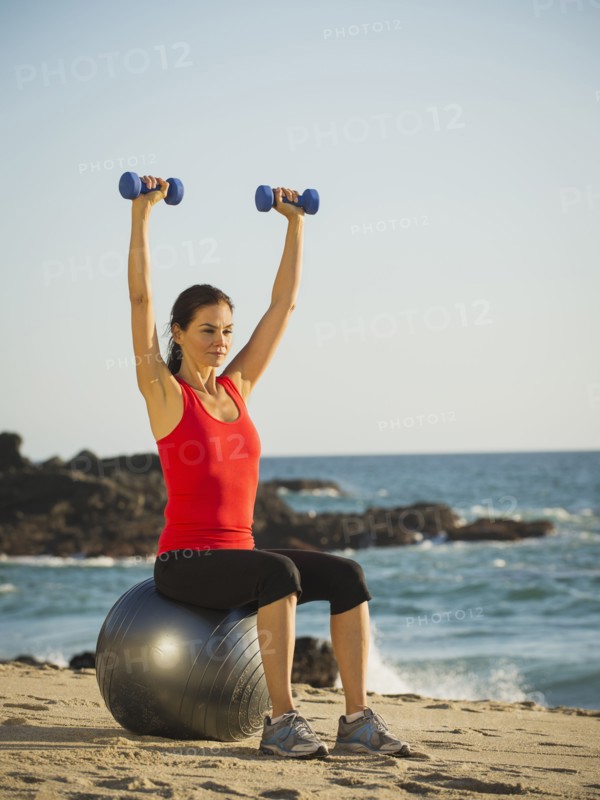 Mixed race woman exercising on beach