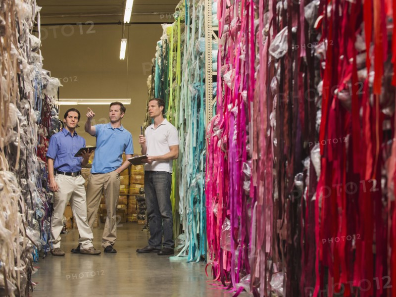 Workers examining fabric in textile factory