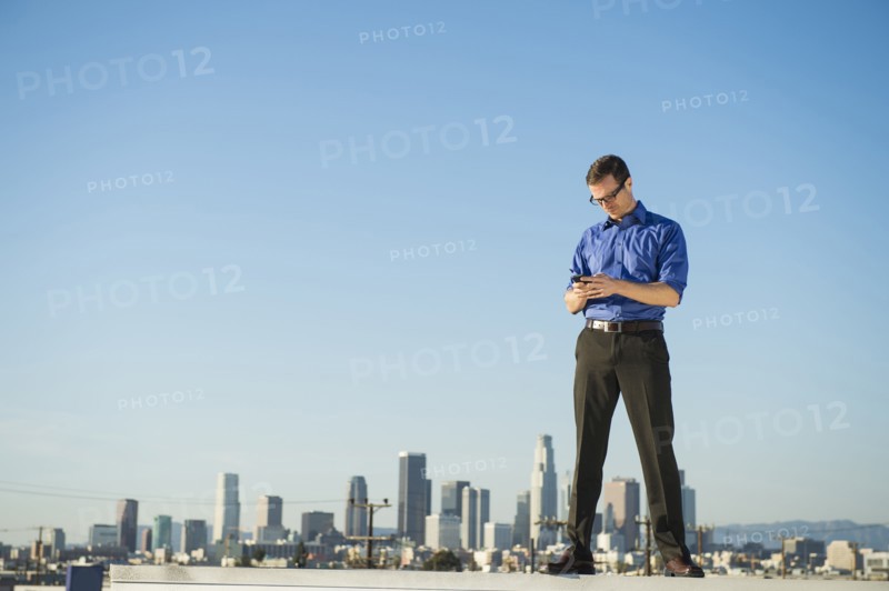 Caucasian businessman standing on urban rooftop
