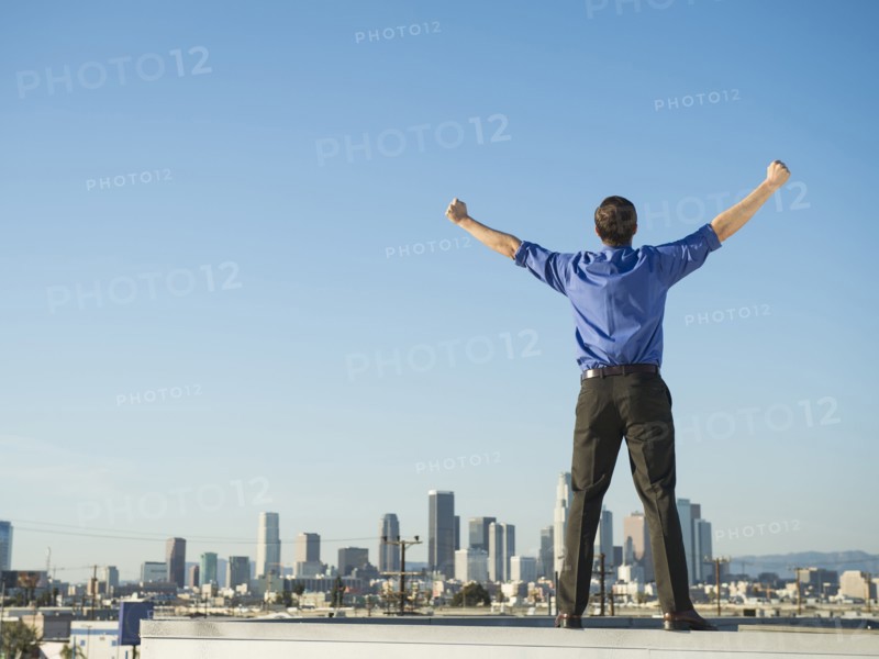 Caucasian businessman standing on urban rooftop
