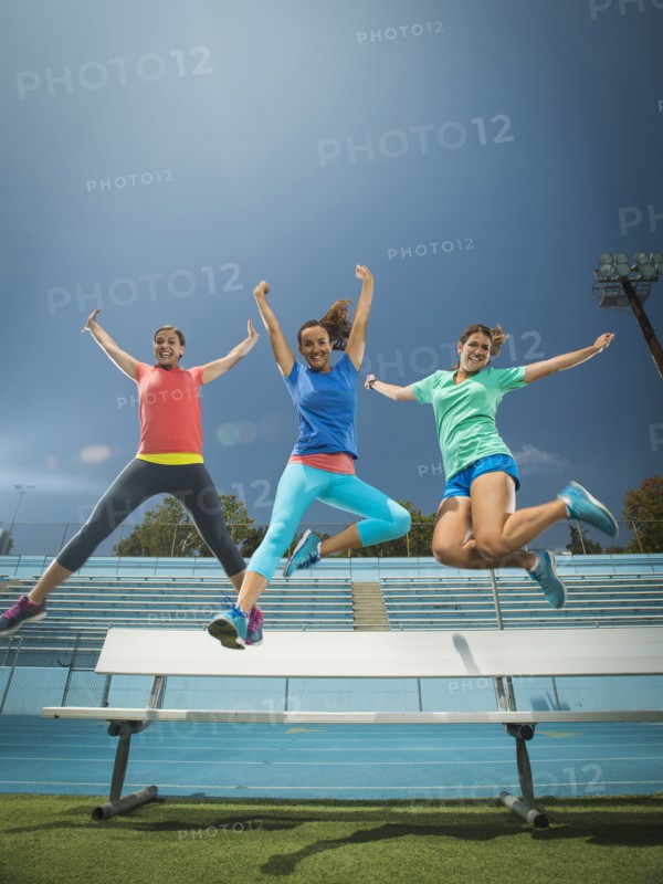 Caucasian women jumping for joy in stadium