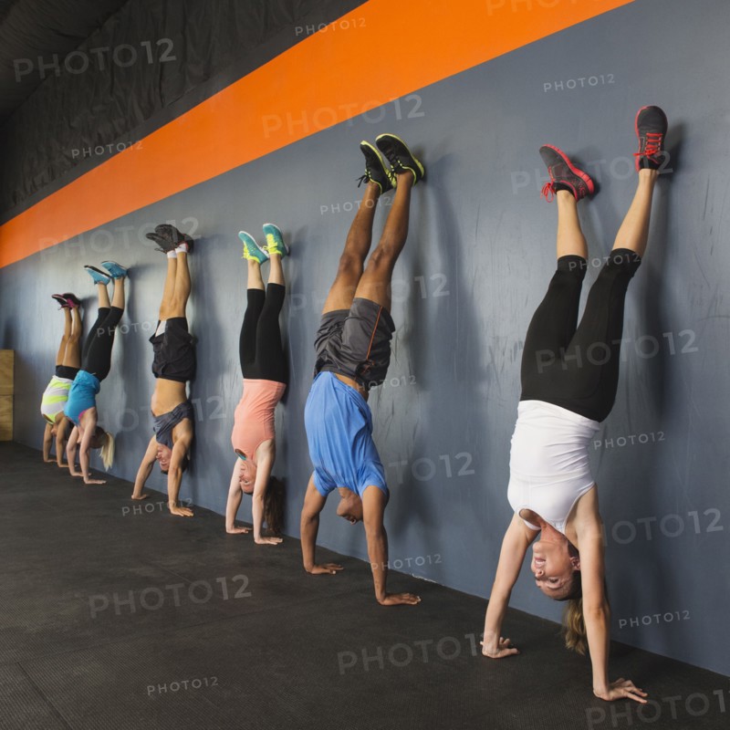 People doing handstands together in gym