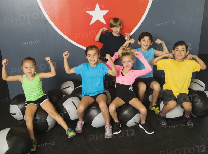 Children flexing their muscles in gym
