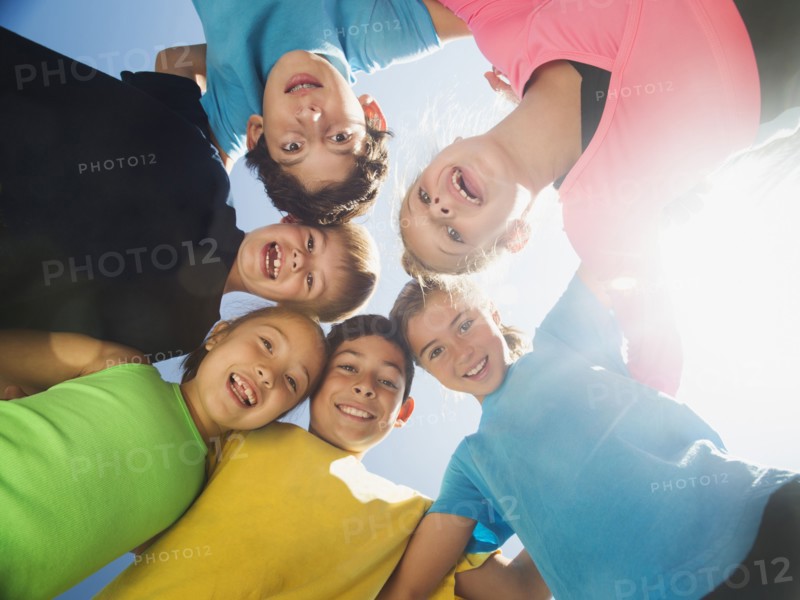 Children smiling in circle outdoors