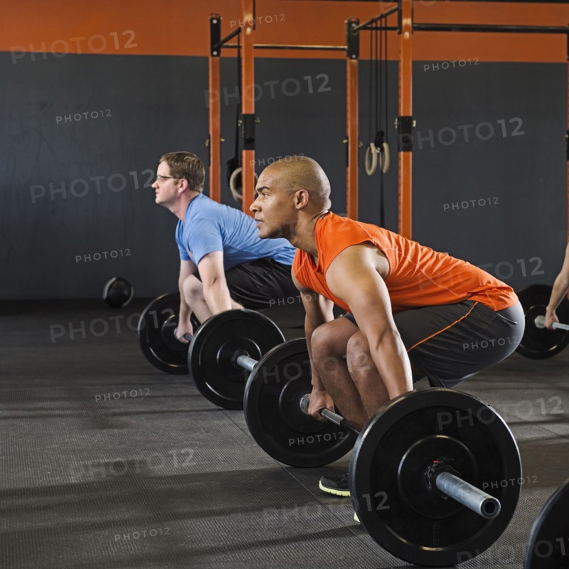 Men lifting weights in gym