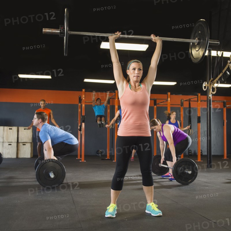 People lifting weights in gym