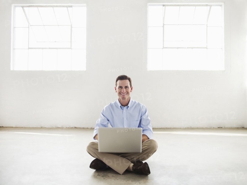 Caucasian businessman using laptop in empty office