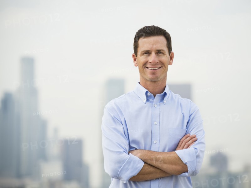 Caucasian businessman standing on urban rooftop