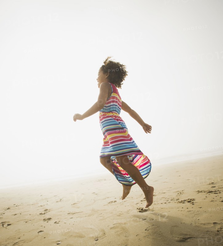 Black girl playing on beach