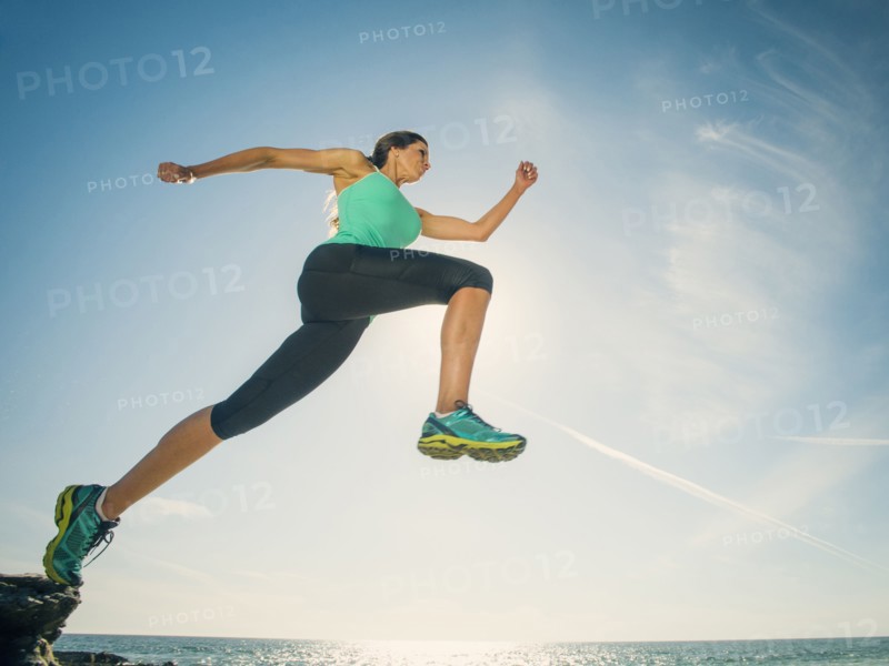 Caucasian woman running on beach