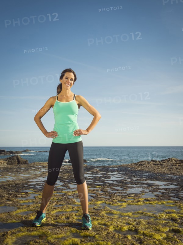 Caucasian runner smiling on beach