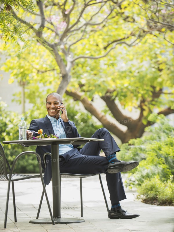 Black businessman working and eating lunch outdoors