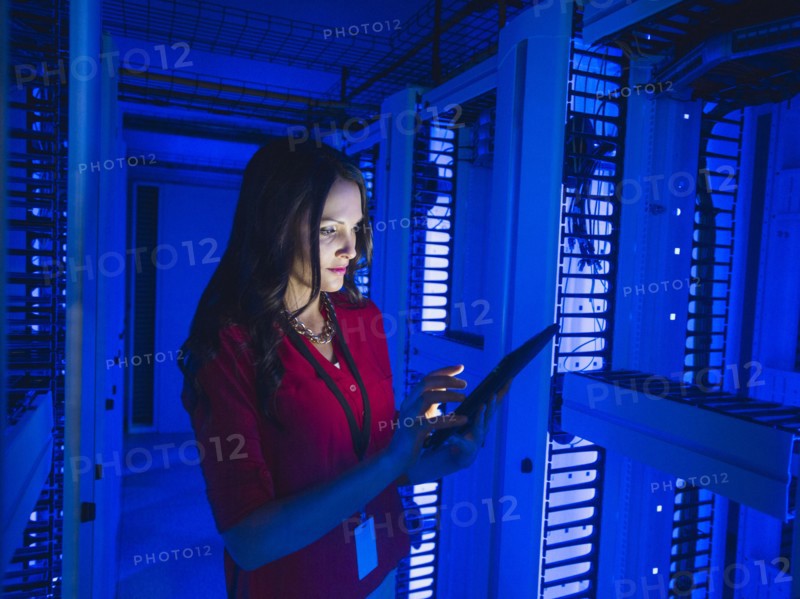 Caucasian businesswoman using digital tablet in server room