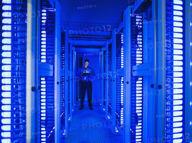 Black businessman using digital tablet in server room
