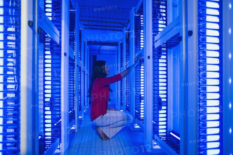 Caucasian businesswoman working in server room
