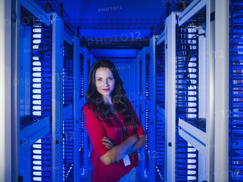 Caucasian businesswoman smiling in server room