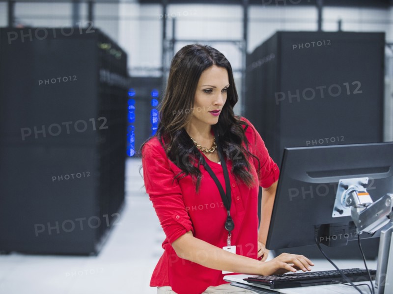 Caucasian businesswoman using computer in server room