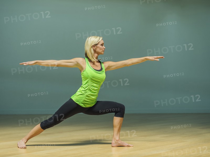 Caucasian woman practicing yoga in studio